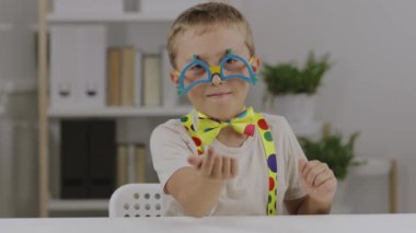 9 yaşında palyaço elbisesi giymiş ve yüzünü buruşturan bir çocuk. Yüksek kalite 4k görüntü