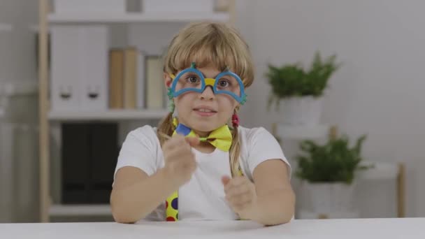 7年の面白い女の子はピエロの目の眼鏡 蝶やサスペンダーに身を包んだ 高品質4K映像 — ストック動画