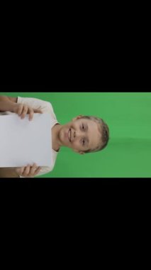 Boy of 9 years holds a sheet of paper. Closeup. High quality footage