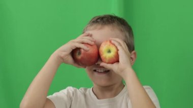 Boy of 9 years is playing with red apples.. Closeup. High quality 4k footage