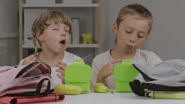 男の子と女の子はテーブルでお菓子を食べている 高品質4K映像 — ストック動画