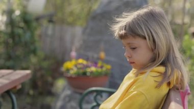 Closeup of a girl of 7 years dressed in a yellow pullover. High quality 4k footage