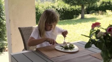 Girl of 7 years old has broccoli as a lunch. High quality 4k footage