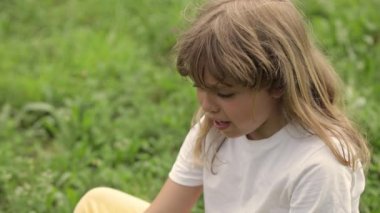 Closeup of a caucasian girl of 7 years old who is complaining in the field. High quality 4k footage