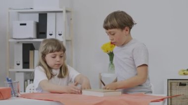 Erkek ve kız kardeş anneleri için hediye hazırlıyorlar. Yüksek kalite 4k görüntü