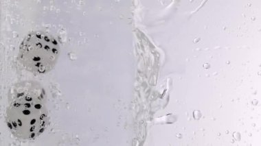 White dices falling in the water. Slow motion. High quality 4k footage