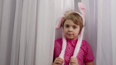 Girl of 7 years old dressed in pink dress and with easter bunny ears. High quality 4k footage
