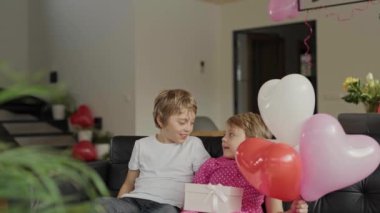 Boy and girl are in the decorated room for Valentines Day. High quality 4k footage