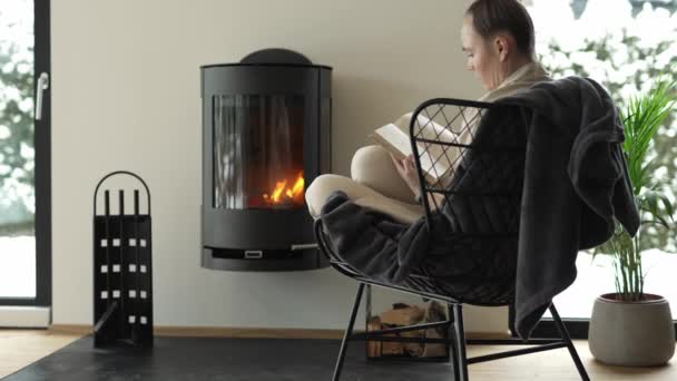 Female Sits Armchair Close Real Chimney Reads Book High Quality — Stockvideo