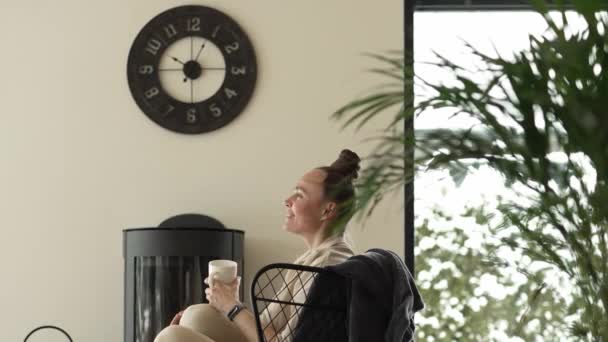 Female Sits Armchair Close Real Chimney Drinks Cup Hot Tea — Vídeo de Stock