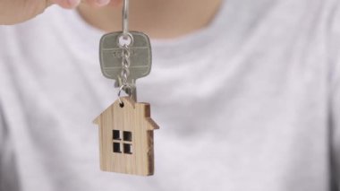 9 yaşındaki bir çocuk anahtar askısını elinde anahtarla bir ev şeklinde tutuyor. Yüksek kalite 4k görüntü