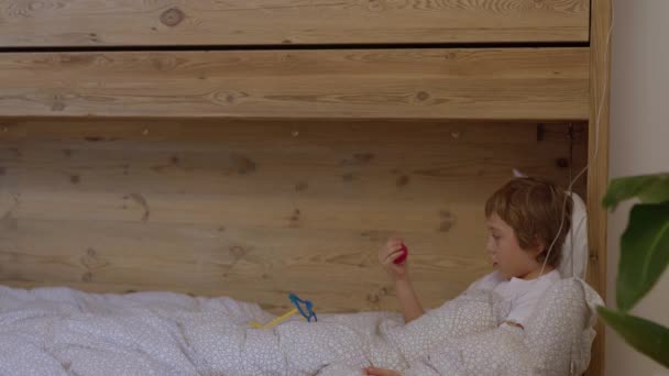 Мальчик Лет Лежит Постели Наблюдает Красным Носом Очками Клоунов Высококачественные — стоковое видео