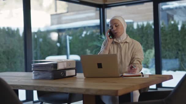 头戴头巾的漂亮女性坐在笔记本电脑前的桌子旁 高质量的4K镜头 — 图库视频影像