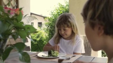 Girl of 7 years old has broccoli as a lunch. High quality 4k footage