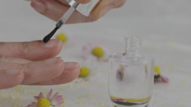 Females covers her nails with transparent nail paint. High quality 4k footage