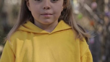 Closeup of a girl of 7 years dressed in a yellow pullover. High quality 4k footage