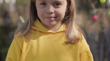 Closeup of a girl of 7 years dressed in a yellow pullover. High quality 4k footage