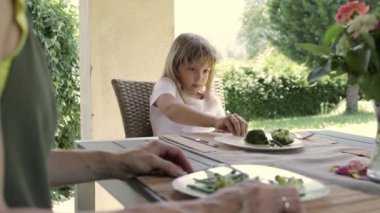 Girl of 7 years old has broccoli as a lunch. High quality 4k footage