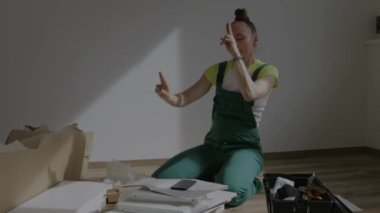 Young female is assembling a piece of furniture. High quality 4k footage