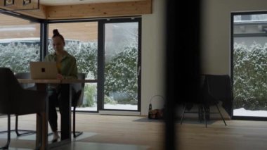 Young female is working at computer sitting at the table. High quality 4k footage