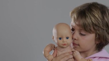 8 yaşındaki bir kız bebeğe sarılıyor. Yüksek kalite 4k görüntü