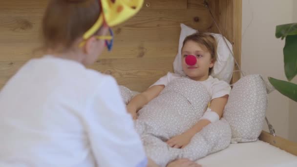 Orvosi Nővér Piros Orrú Egyenruhában Játszik Egy Lánnyal Kórtermében Kiváló — Stock videók