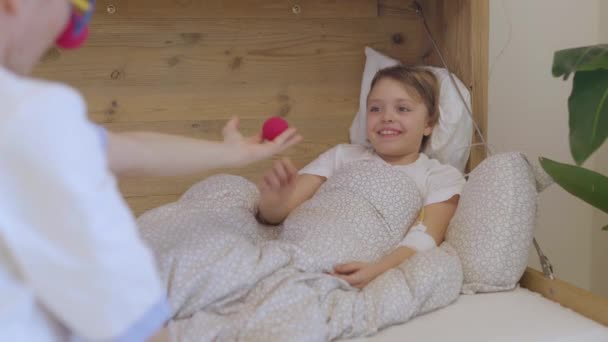 Orvosi Nővér Piros Orrú Egyenruhában Játszik Egy Lánnyal Kórtermében Kiváló — Stock videók