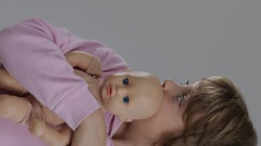 8 yaşındaki bir kız bebeğe sarılıyor. Yüksek kalite 4k görüntü