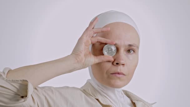 若いイスラム教徒の女性の間に35と40歳で頭スカーフビットコインを保持 — ストック動画