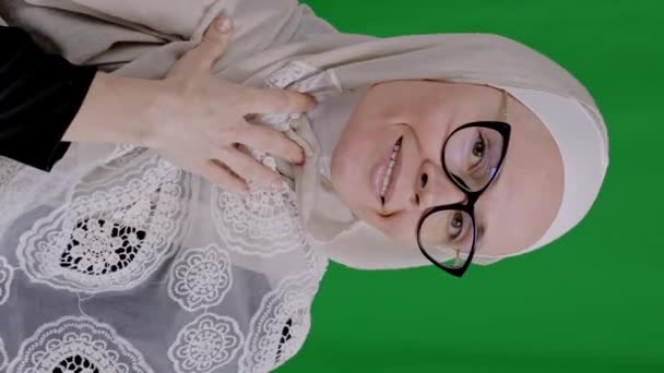 年龄在35岁至40岁之间的迷人的穆斯林女性 戴着眼镜 头戴头巾 吹着她的手掌 高质量的4K镜头 — 图库视频影像