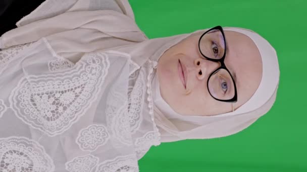 年龄在35岁至40岁之间的迷人的穆斯林女性 戴着眼镜 头戴头巾 吹着她的手掌 高质量的4K镜头 — 图库视频影像