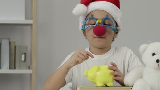 9岁的男孩戴着圣诞老人的帽子 请求施舍 穿上衣服高质量的4K镜头 — 图库视频影像