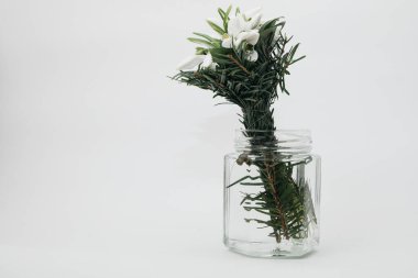 Beyaz arka planda vazoda bir buket bahar çiçeği.