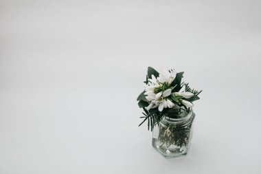 Beyaz arka planda vazoda bir buket bahar çiçeği.