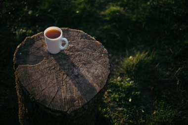 Bir fincan kahve, ahşap tezgahta çay.
