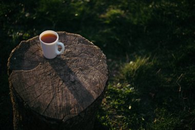 Bir fincan kahve, ahşap tezgahta çay.