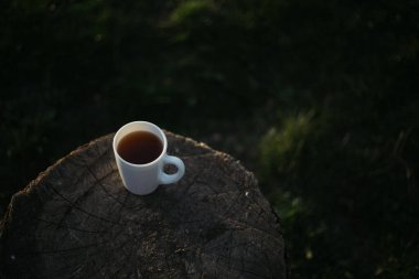 Bir fincan kahve, ahşap tezgahta çay.