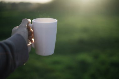 Bir adam elinde bir fincan kahve, çay ve hareket
