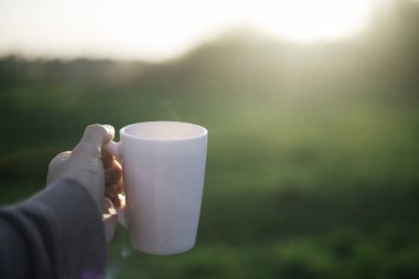 Bir adam elinde bir fincan kahve, çay ve hareket