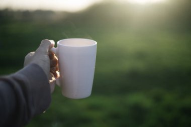Bir adam elinde bir fincan kahve, çay ve hareket