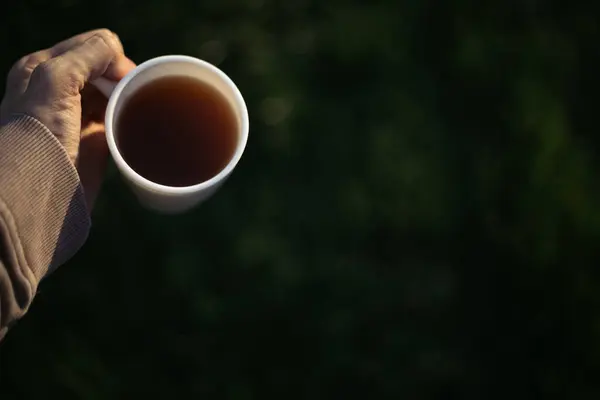 Bir adam elinde bir fincan kahve, çay ve hareket