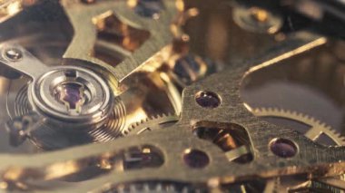 Metalik dişliler ve dişliler mekanik saatin içinde dönüyor..