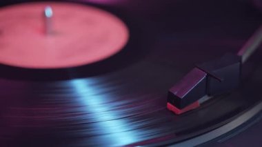 LP albümünden müzik çalan vinil plak çalar.