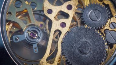 Metalik dişliler ve dişliler mekanik saatin içinde dönüyor..