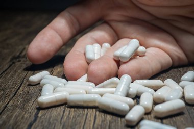 Bir adamın elinde bir sürü hap. Aşırı doz kavramı.