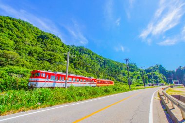Kırmızı tren sahil boyunca ilerliyor. Atış yeri: Akita Bölgesi