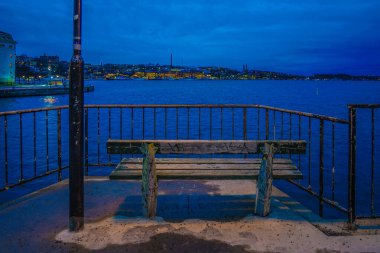 Bankın ve mavi denizin gece manzarası. Çekim yeri: İsveç, Stockholm