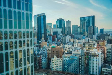 Binaların ve gökyüzünün renklerini yansıtıyor. Çekim yeri: Shinjuku Koğuşu, Tokyo