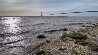 Hessle 'daki Humber Köprüsü, İngiltere, Hull' dan. Gelgit nehir kıyısına doğru geliyor.