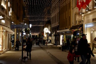 Christmas decorations and crowds of people walking on the street at night in Luxembourg, Luxembourg - December 27, 2022